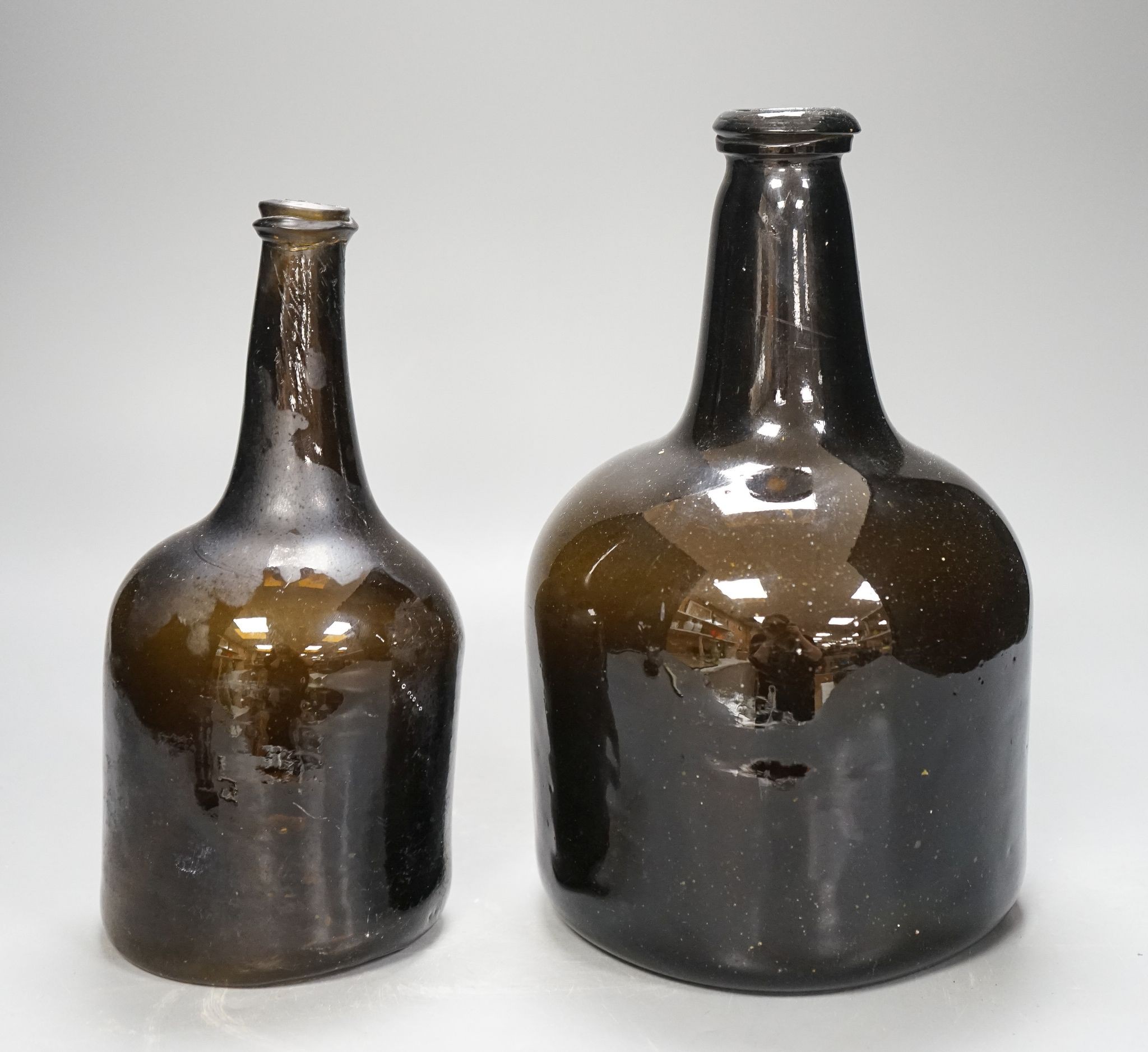 Two mid 18th century glass mallet-shape wine bottles, tallest 27cm